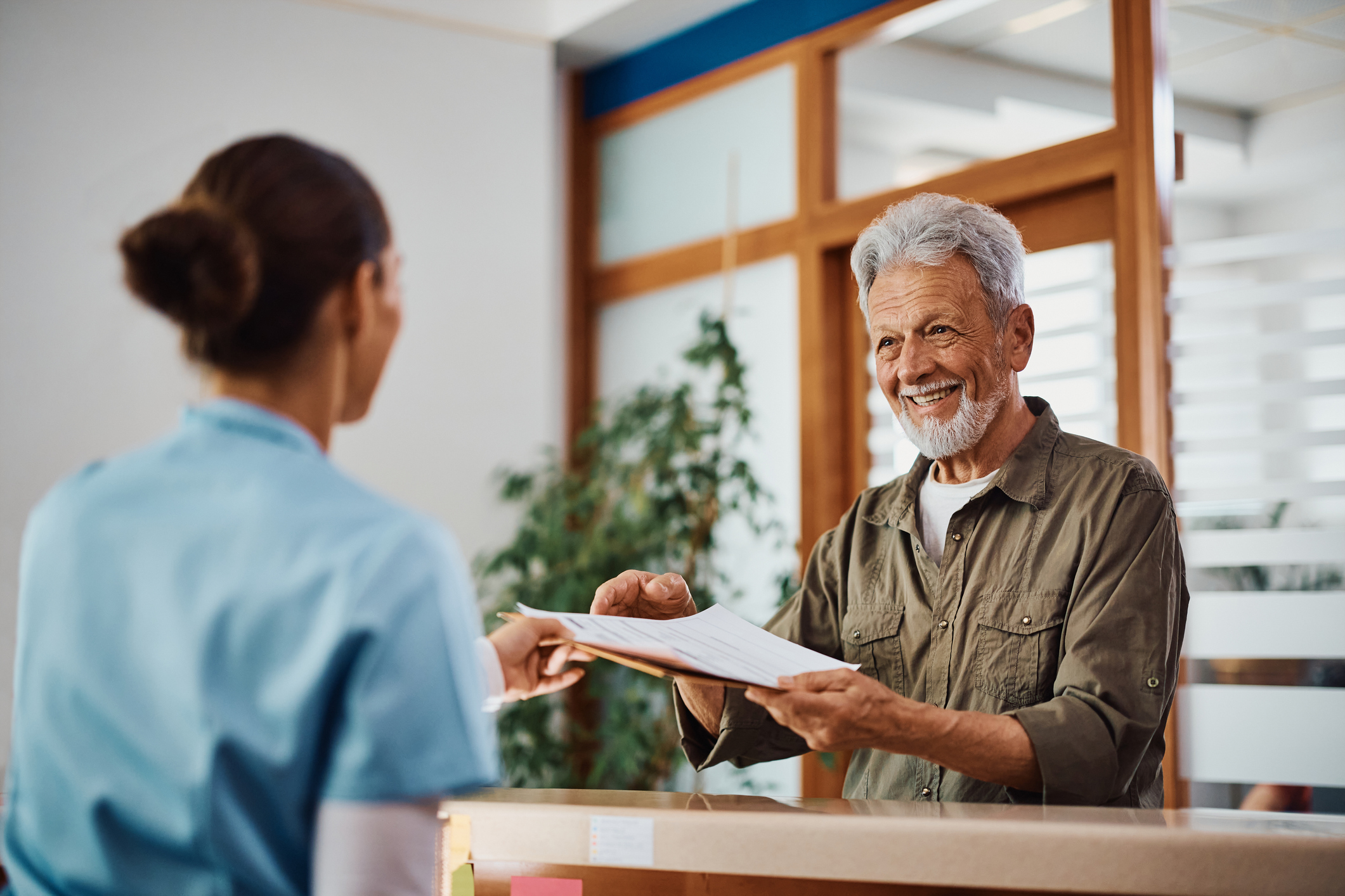 happy senior male with medical documents